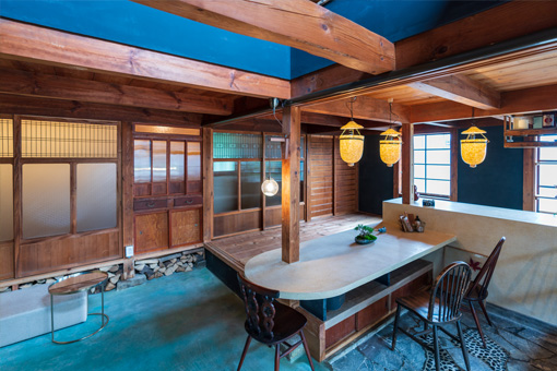 Interior of Art Canvas Awashima. Many traditional Japanese home features, such as multi-level floors, exposed roof beams, and sliding doors are visible in the largely wood and stone interior.